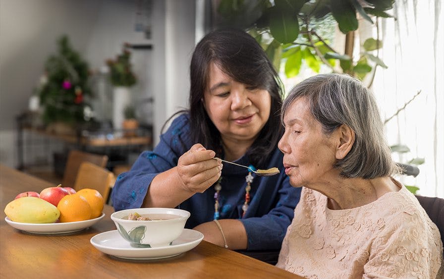  a woman feeding an old woman