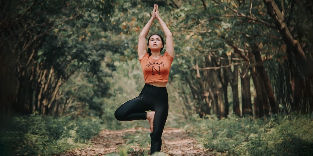 lady doing yoga in the middle of the forest