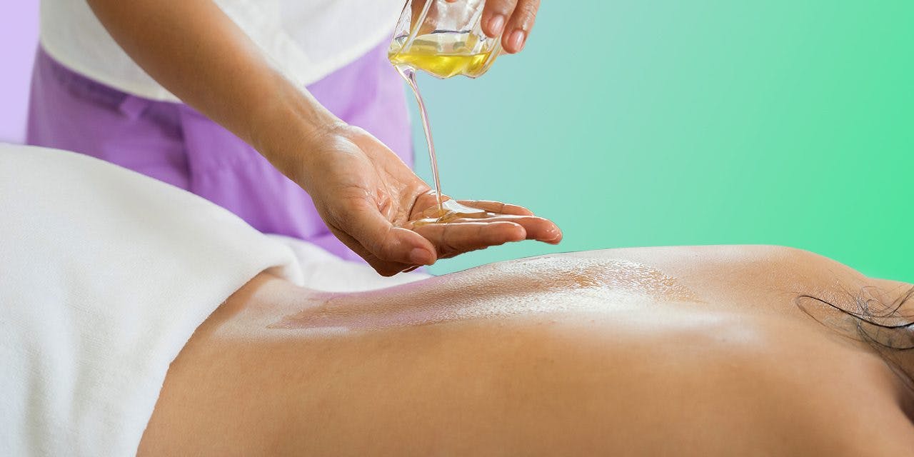 pouring oil on the therapist's hand and then on the back of a woman below.