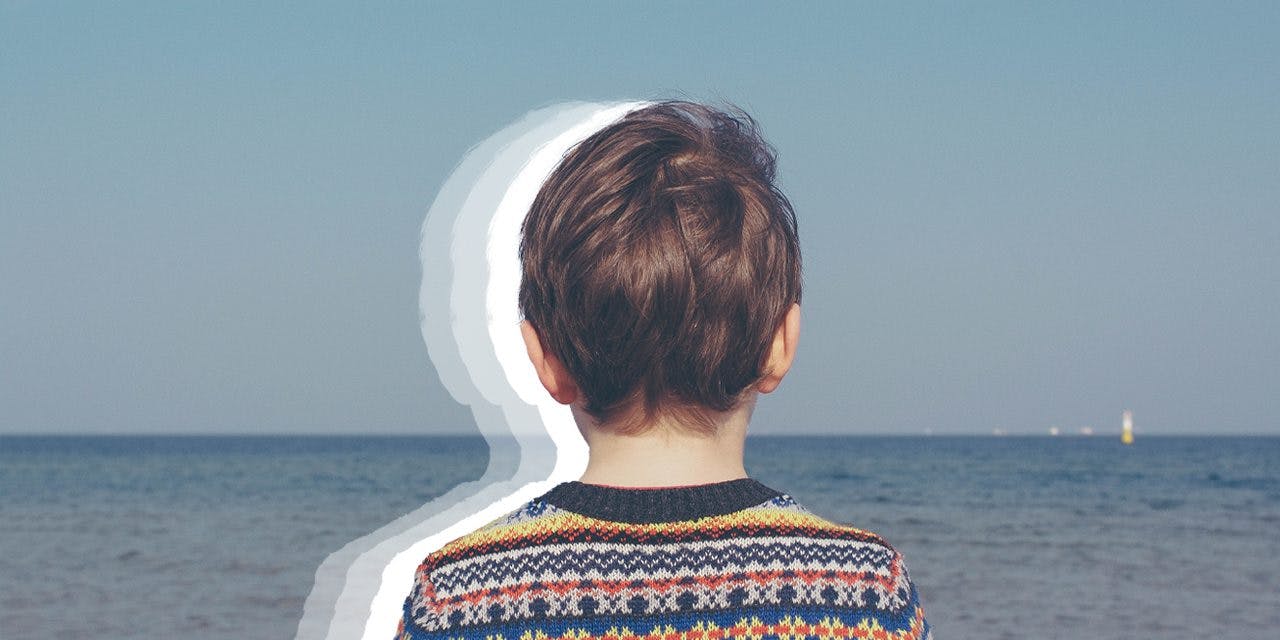 a child's back fronting a beach