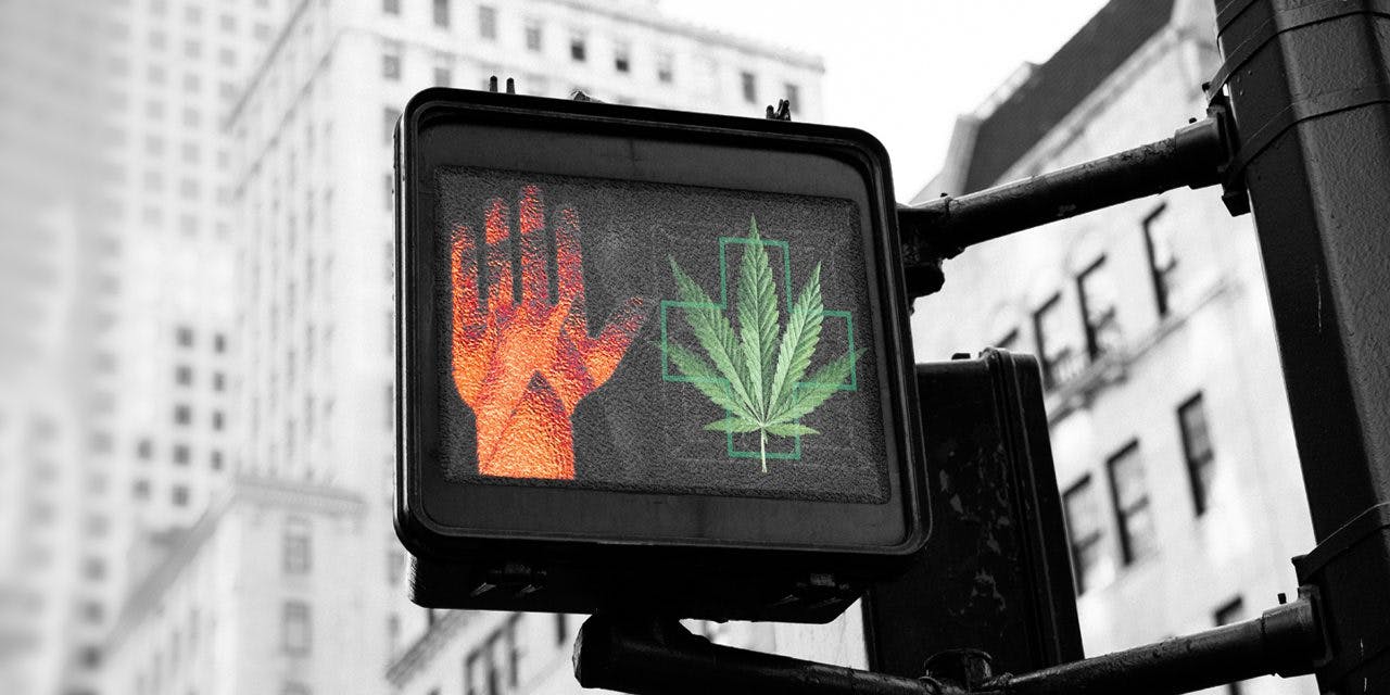 hand stop sign and medical marijuana sign in traffic post, tall buildings in the background