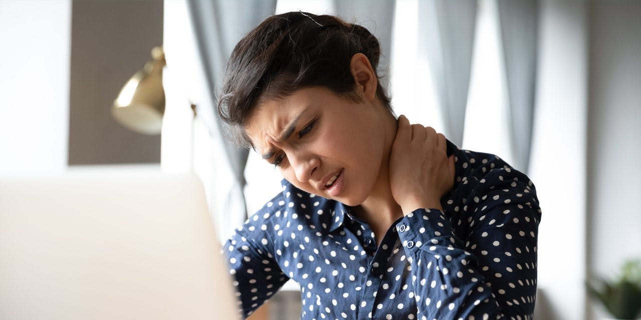 woman in pain, touching or pressing the back of her neck