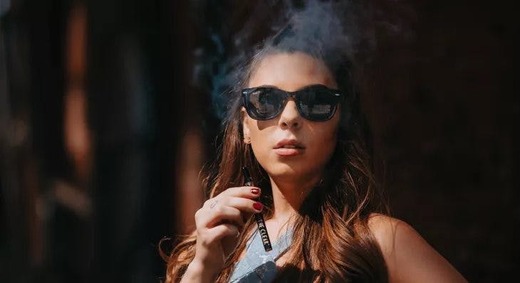 young woman smoking from a vape pen