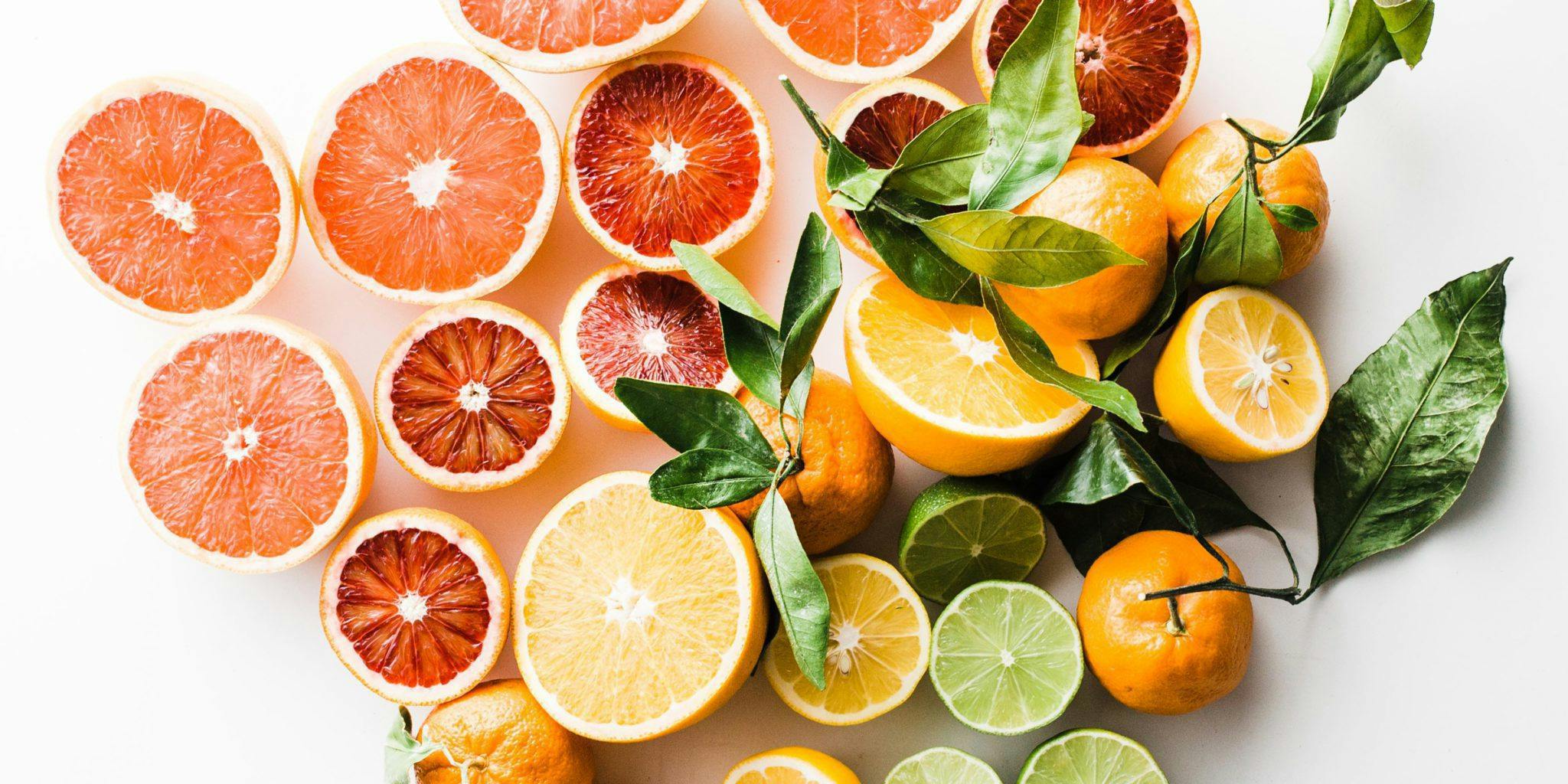 sliced oranges and leaves on a white background