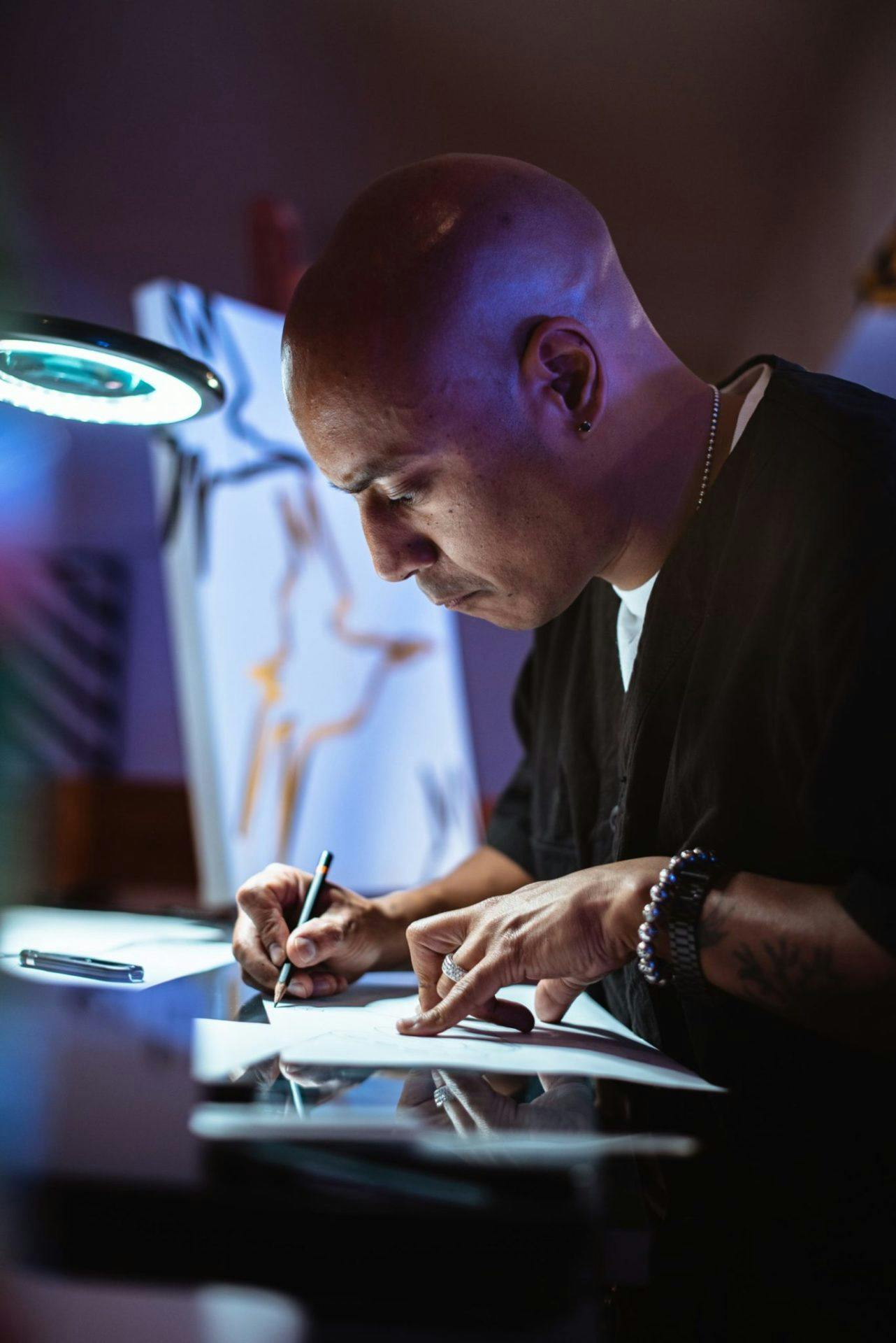 man focus on his drawing in a dim light room