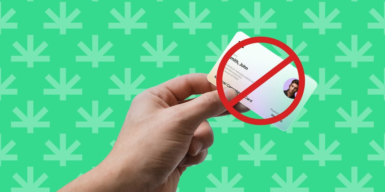 closeup hand holding medical marijuana card with prohibition sign on card