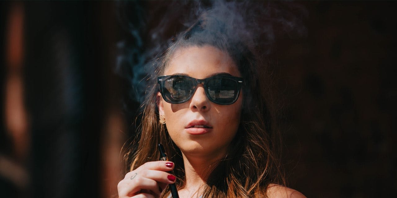 woman with sunglasses smoking weed