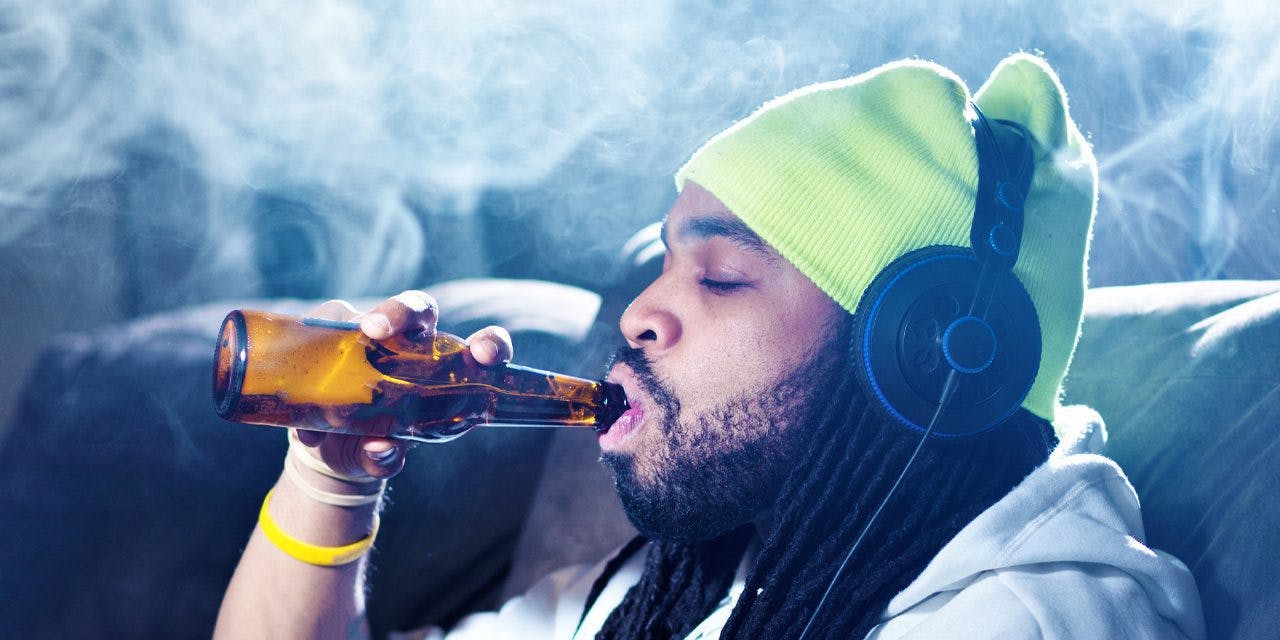 man drinking liquor with smoke above his head