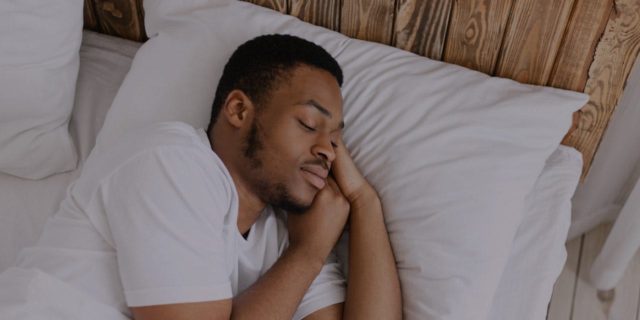 man sleeping soundly on his bed