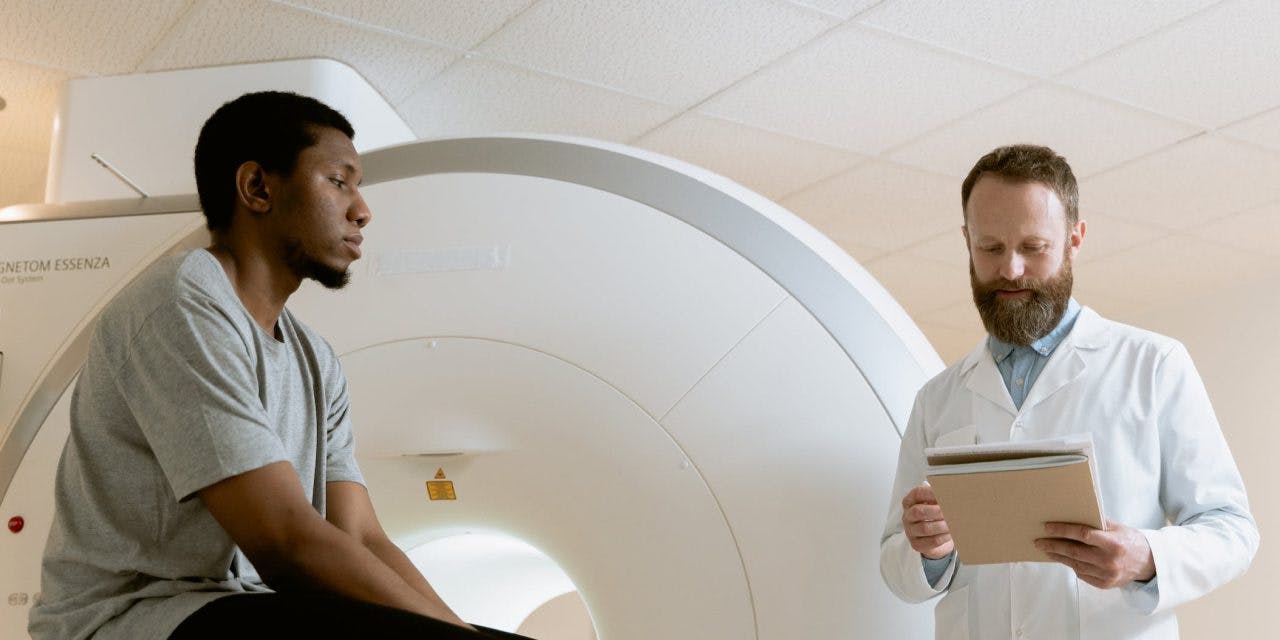a patient listening to his doctor's explanation outside the MRI machine