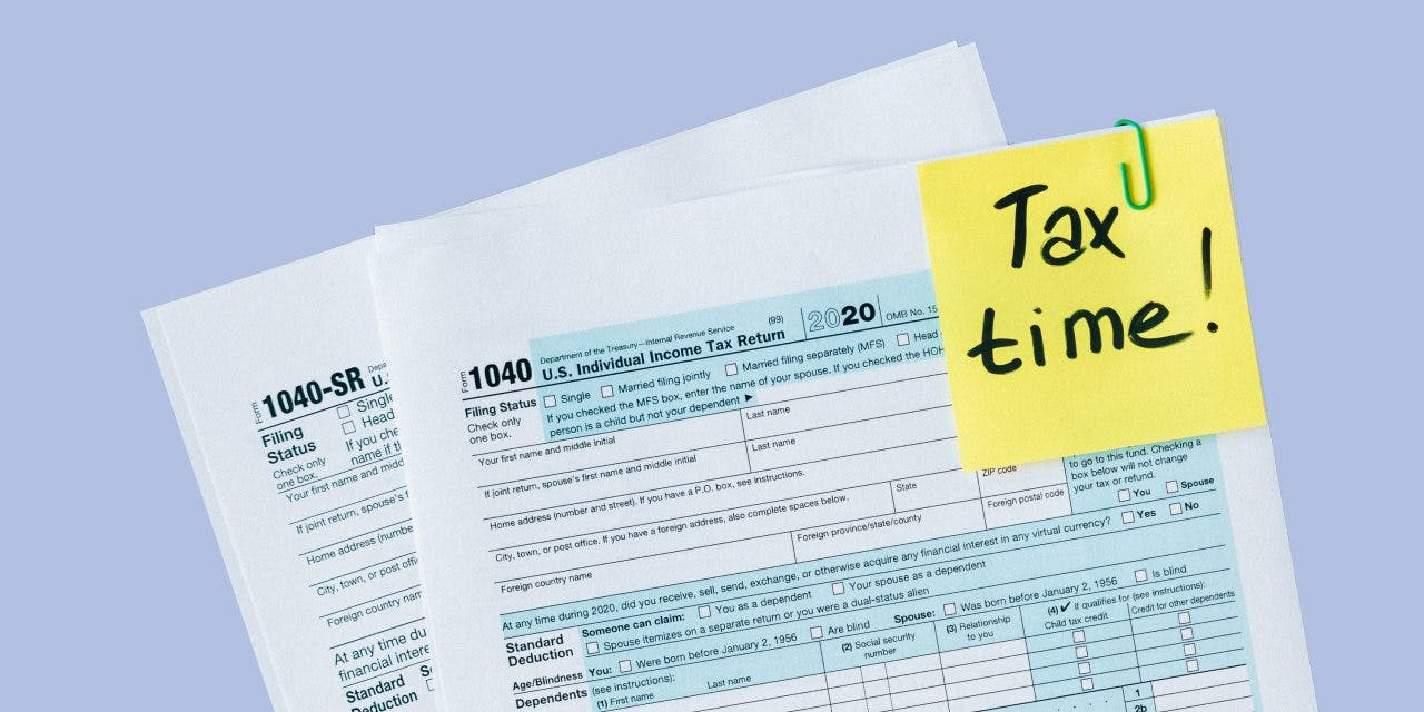 tax forms with a clipped note says 'Tax time!'