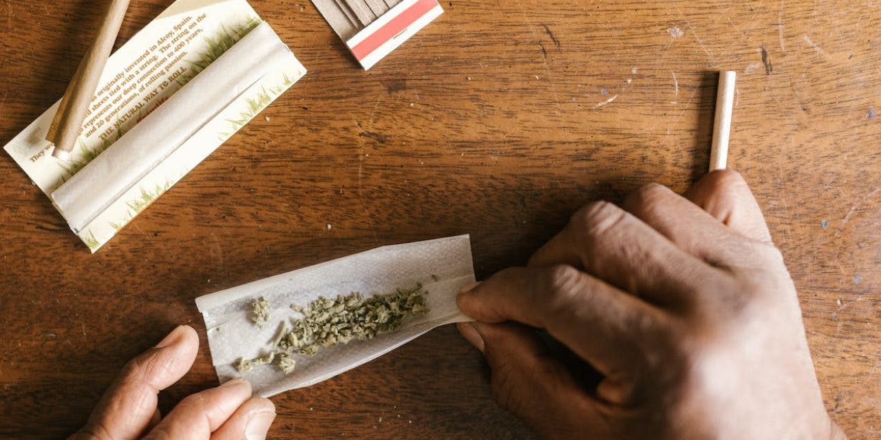 closeup hands rolling a cannabis joint