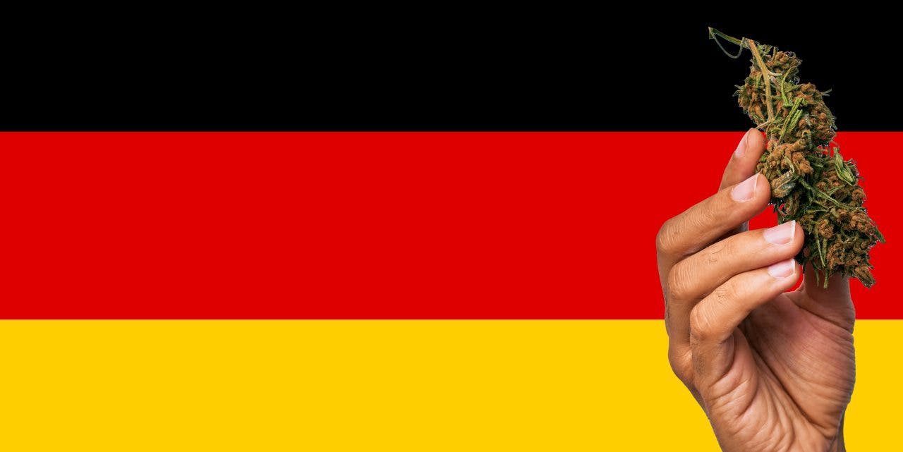 Germany flag with a hand holding a marijuana infront of it