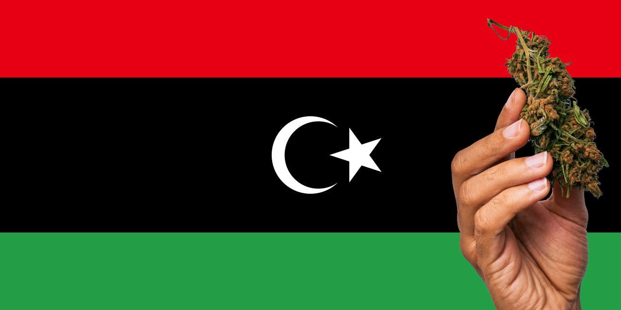 Libya flag with a hand holding a marijuana infront of it