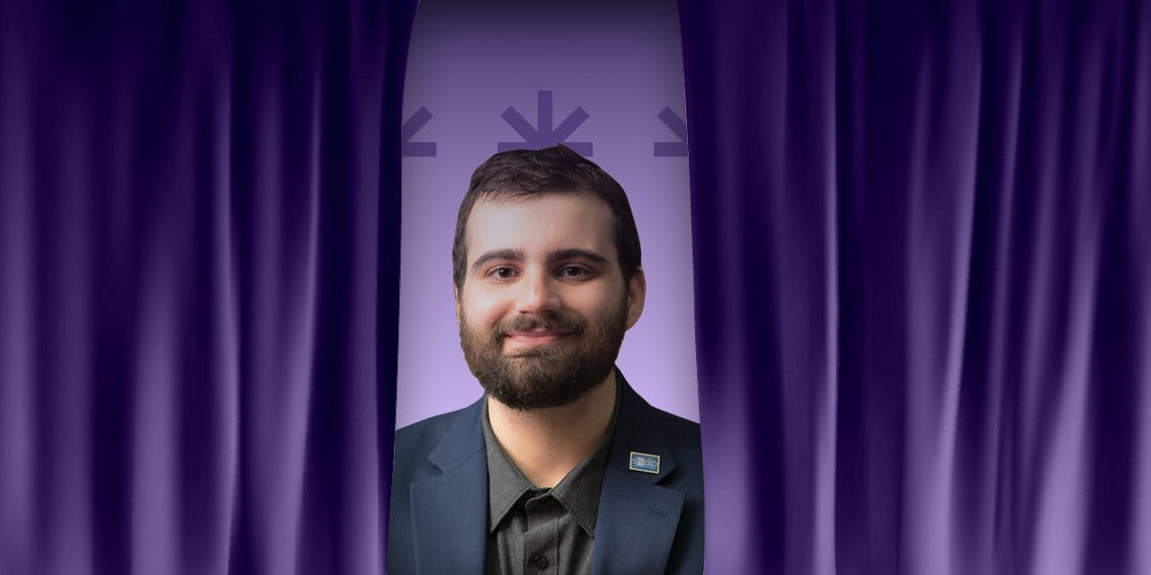 Jake Agliata is pictured on a purple background with parting purple curtains.